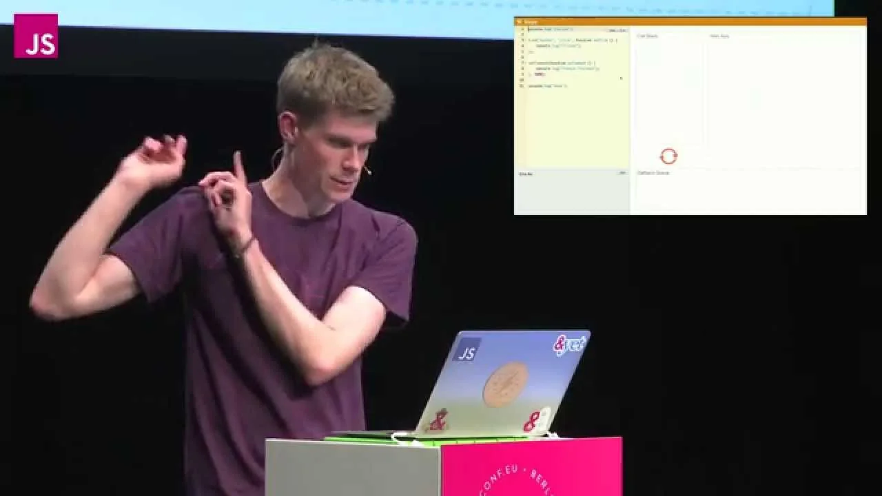 Philip Roberts on stage at JSConf EU 2014, presenting his Loupe call-stack visualiser projected on the screen behind him.